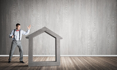 Stone home silhouette in empty room as symbol for real estate insurance