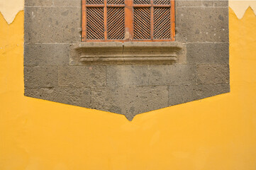 Colorful detail of an old window on an orange-painted wall. High-quality photo