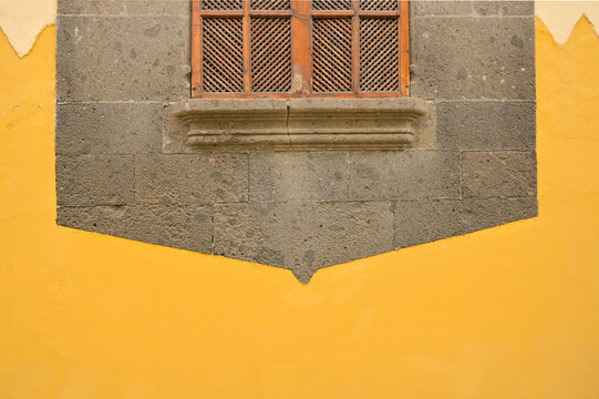 Colorful detail of an old window on an orange-painted wall. High-quality photo