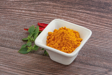 Yellow vibrant curcuma powder in the bowl