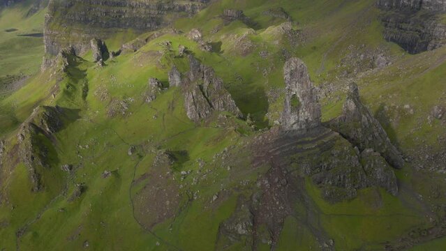 Aerial fly over above the Old man of Stor on the Isle of skye through the clouds with sunbursts during sunris