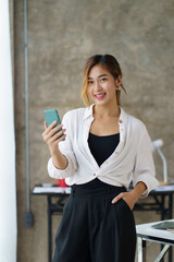 Asian business women are enjoying using smartphone and social media application with pleasure and pleasure at the office.