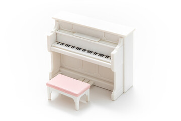 Miniature piano isolated on white background. Miniature dollhouse furniture. Kids toy. Play and learn. Kids room. Childhood. Kindergarten toy. Developmental toys. Plastic toy.
