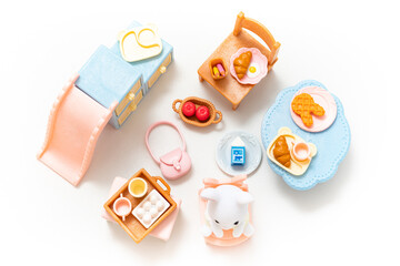 Miniature dollhouse furniture isolated on white background. Animal doll. Kids toy. Play and learn. Kids room. Childhood. Kindergarten toy. Developmental toys. Tiny dining table. Cute doll. Family.
