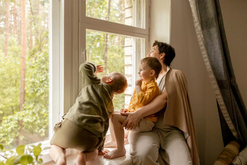 Happy grandmother and her grandsons enjoy time together. Positive middle age woman spending time...