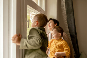 Happy grandmother and her grandsons enjoy time together. Positive middle age woman spending time...
