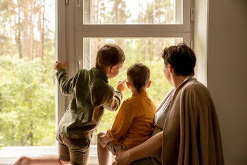 Happy grandmother and her grandsons enjoy time together. Positive middle age woman spending time...