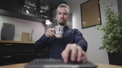 One hand typing on laptop with the morning coffee drinking in kitchen 4K