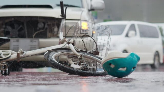 Bicycle helmet spinning and falling down bicycle on the road after traffic accident on a raining day