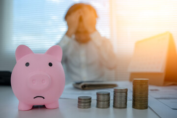 Piggy bank sad with pile coins. Debt and expenses problems, paying taxes, home installments, car...