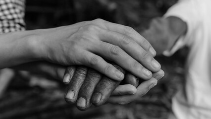 Hands of the old man and a man hand black and white