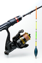Fishing rod with a reel and float on a white background.