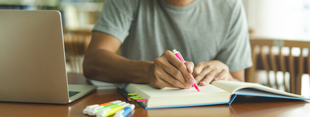 male asian student studying and reading book in library