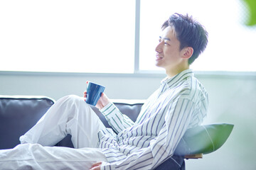 リビングでくつろぐ若い日本人の男性