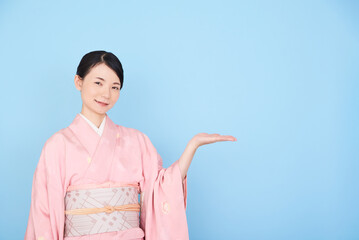 手で案内する着物を着た女性