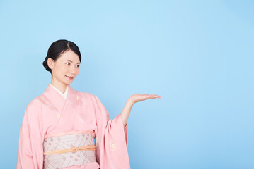 手で案内する着物を着た女性