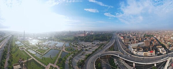An early morning panorama of Aazadi Chowk, Badshahi Mosque and Pakistan monument, captured after rain but in a clear blue sky with some clouds. 