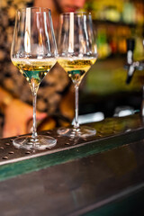 Two glasses of cold dry white wine on bar
