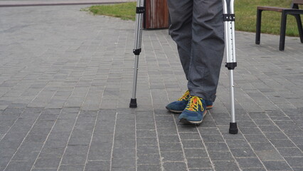 Legs of a man standing with crutches