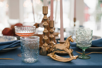Vintage horse, glass glasses and candlesticks in the festive setting of the Christmas table