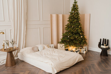 Stylish bright bedroom with a bed and a Christmas tree with gifts. Interior apartments