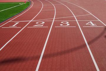 Running track. Red treadmill at the stadium with white lines.