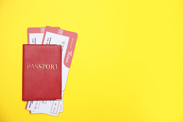 Passport with tickets on yellow background, top view. Space for text