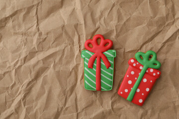 Christmas gift shaped gingerbread cookies on crumpled parchment, top view. Space for text
