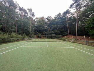 Fototapeta premium Tennis court with green grass and net outdoors