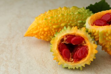 Fresh bitter melons with red seeds on light table, closeup