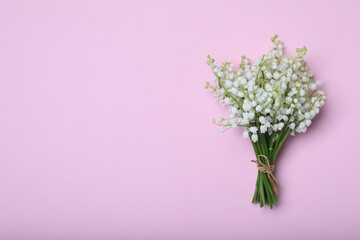 Beautiful lily of the valley flowers on pink background, top view. Space for text