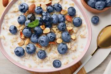Flat lay composition with tasty oatmeal porridge and ingredients served on wooden table. Healthy meal
