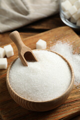 Granulated sugar in bowl on wooden table