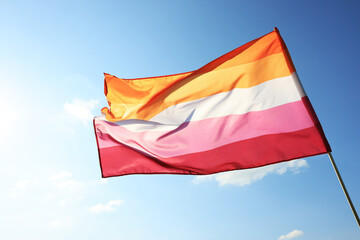 Fototapeta na wymiar Bright lesbian flag fluttering against blue sky