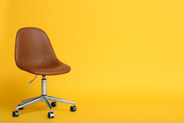 Modern office chair on yellow background. Space for text