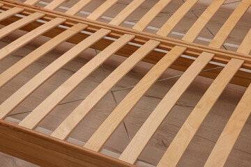 Wooden bed frame on floor, closeup view