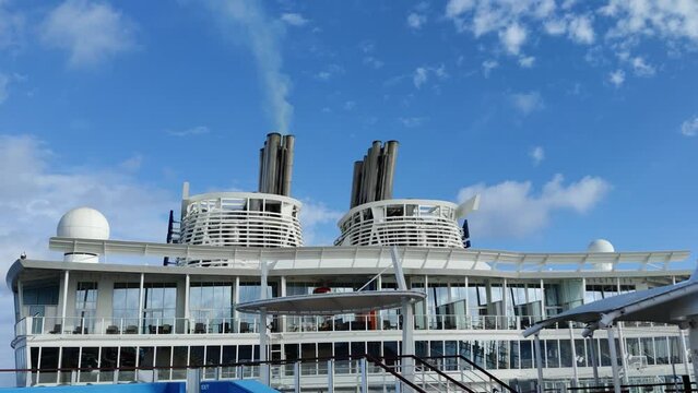 Huge Cruise ship Chimney or smoke funnel with a smoke billowing out in the skies video background | one Smokestack out of two on cruise ship with smoke billowing out into the sky