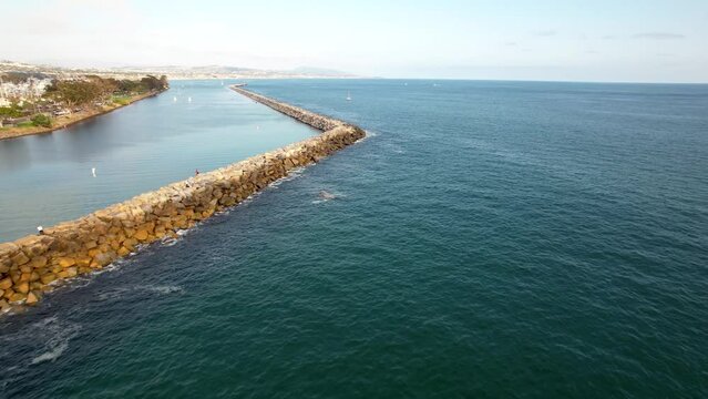 The stone jetty at Dana Point, California harbor protects the marina and shoreline from erosion - aerial flyover