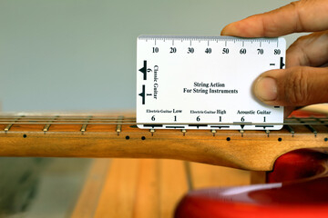 Adjust the action of the electric guitar with a level gauge