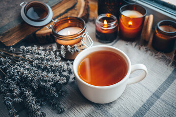 A cup of herbal tea with burning candles, aesthetically warm photo