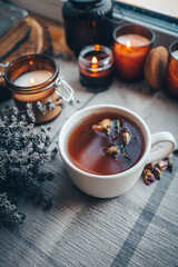 A cup of herbal tea with burning candles, aesthetically warm photo