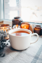 A cup of herbal tea with burning candles, aesthetically warm photo