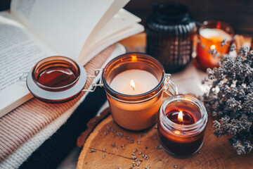 Burning candles, book and lavender, aesthetic autumn photo