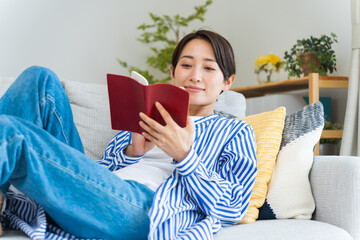 ソファで読書する日本人女性