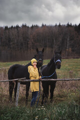 Girl with horses in the field. Horses in autumn.