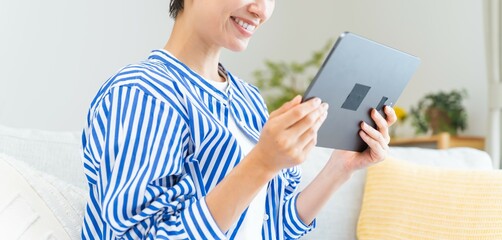 タブレットを横に持ち見る日本人女性