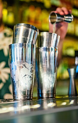 various steel shakers stand on the bar counter