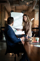 Businesswoman present her idea to working team. Young beautiful woman presenting businessplan