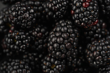 a heap of fresh ripe blackberries in a black plate