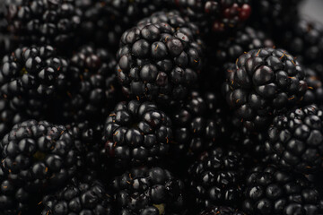 a heap of fresh ripe blackberries in a black plate
